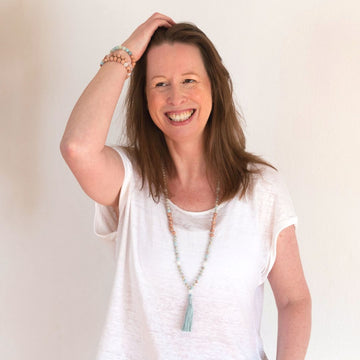 Woman with white top wearing a Handmade Focusing Mala Necklace – Rosewood, Moonstone & Jasper